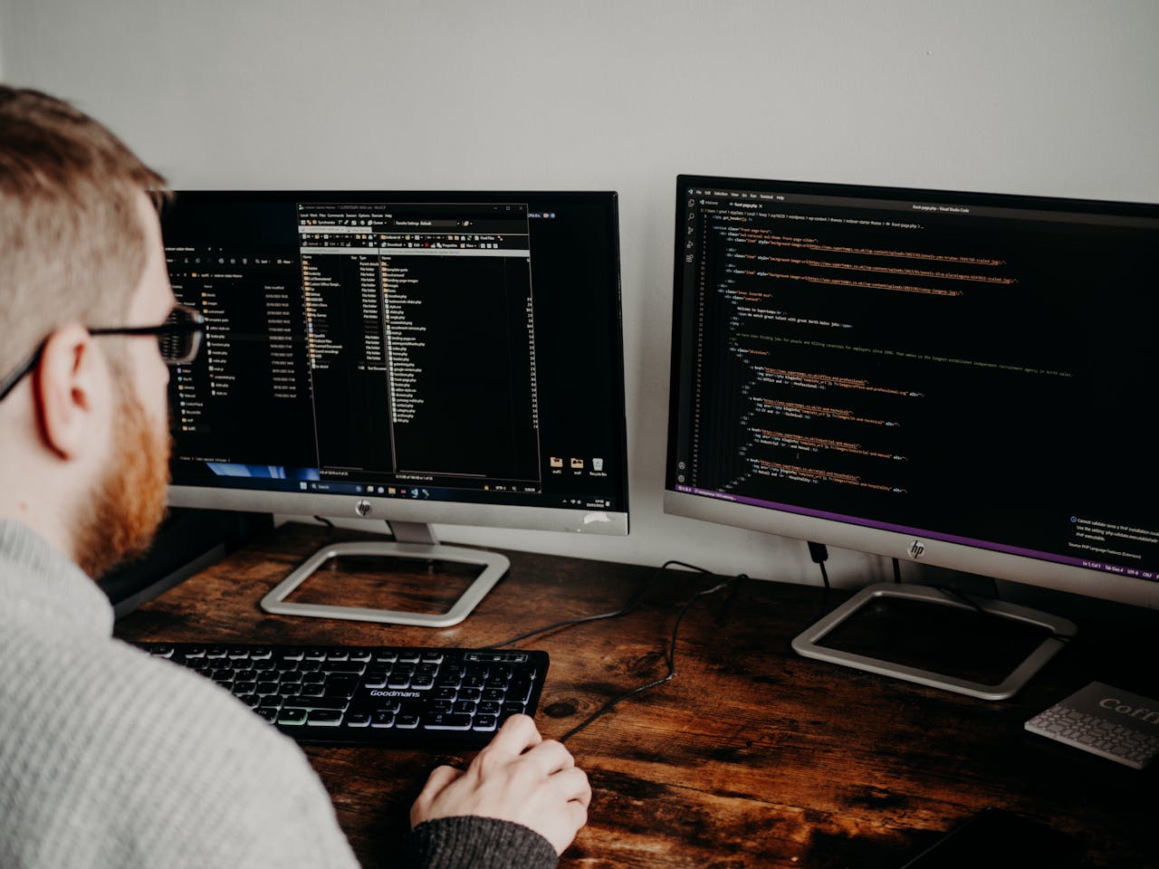 Man Coding on Computers Sitting at Desk doing web development